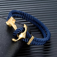 Bracelet double cordon bleu foncé avec motif ancre dorée, style nautique élégant.