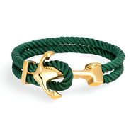 Bracelet double cordon vert avec motif ancre dorée et fermoir doré élégant.