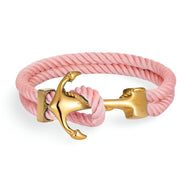 Bracelet double cordon rose avec motif ancre dorée en métal brillant.