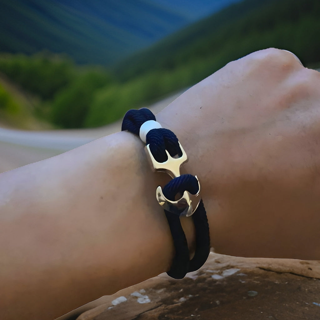 Bracelet double cordon noir avec motif ancre en métal argenté, style marin élégant.