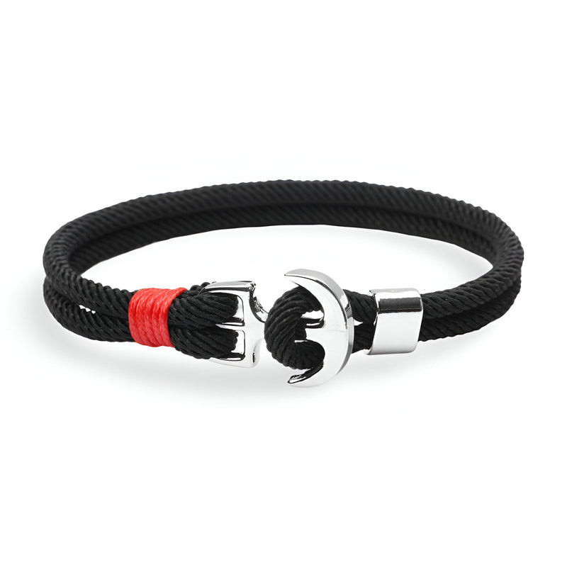 Bracelet double cordon noir avec motif ancre large argenté et détail rouge en nylon tressé.