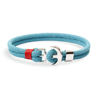 Bracelet double cordon bleu clair avec motif ancre argentée et détail rouge.
