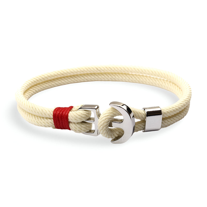 Bracelet double cordon blanc avec motif ancre argentée et détail rouge en tissu côté fermoir.