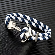 Bracelet double cordon bleu et blanc torsadé avec motif ancre argentée polis.