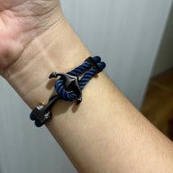 Bracelet double cordon bleu avec motif ancre noire en métal, style marin élégant.