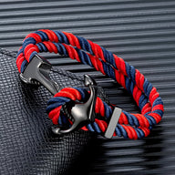Bracelet double cordon rouge et bleu avec motif ancre noire en métal brillant.