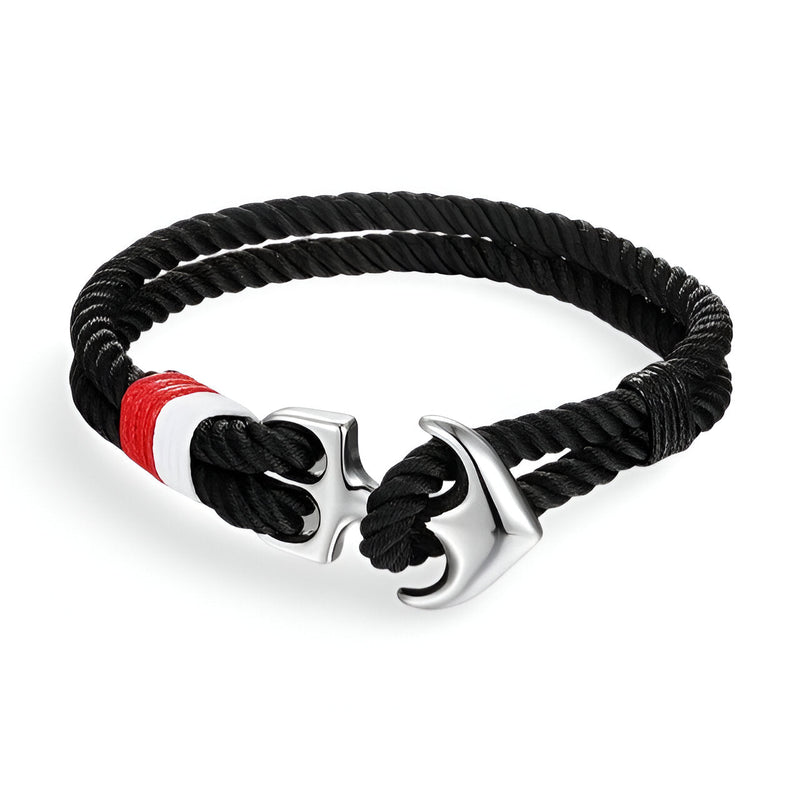 Bracelet double cordons noirs avec ancre marine argentée et détail rouge et blanc.