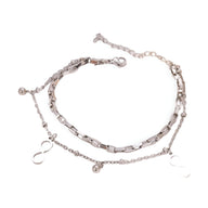 Bracelet double en acier inoxydable argenté avec charms infini et petite médaille suspendue.