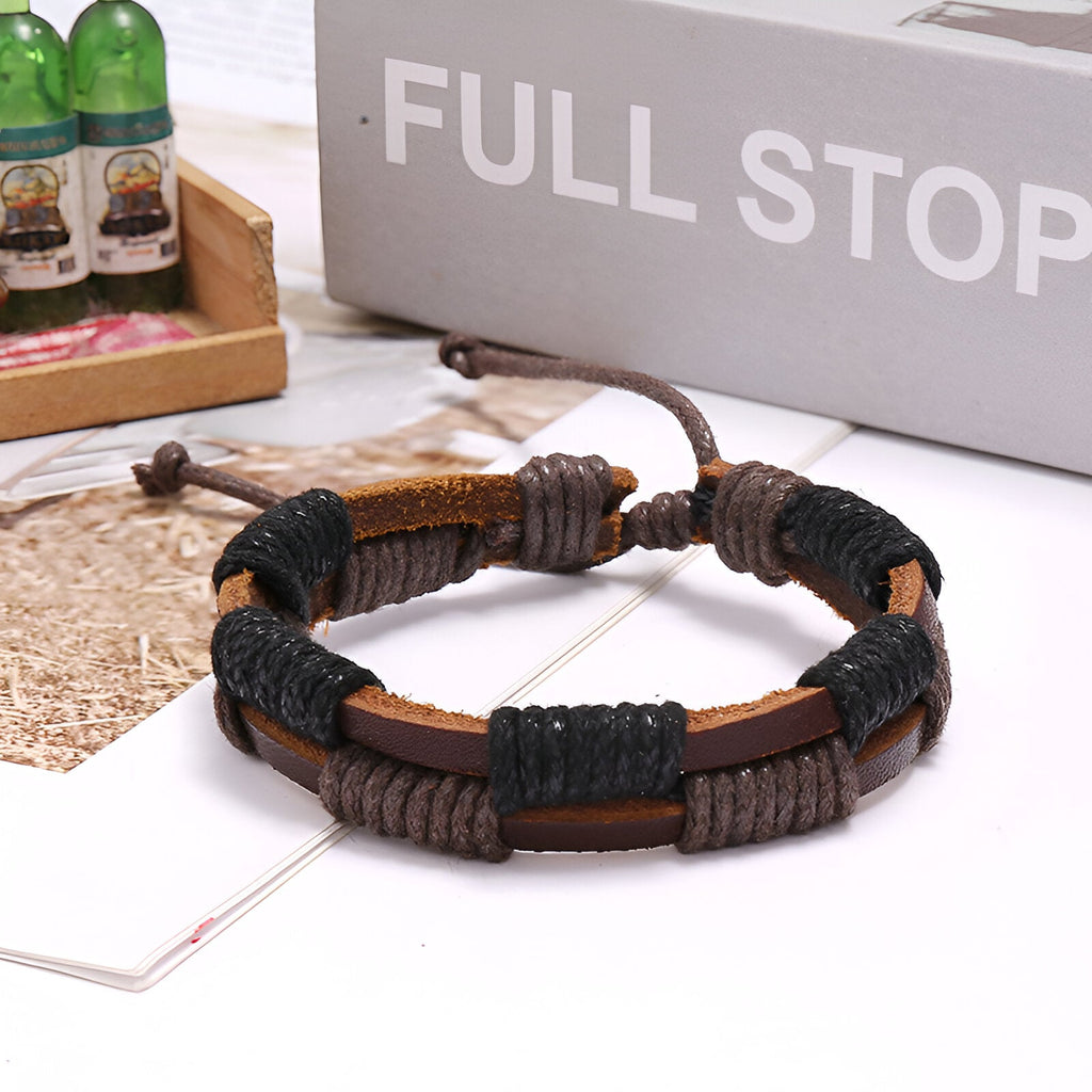 Bracelet double en cuir marron avec détails cirés noirs et fermeture ajustable par nœuds.