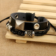 Bracelet double noir en cuir avec détails métallisés argentés et tresse décorative.