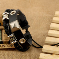 Bracelet double en cuir noir avec détails métallisés argentés et fermoir ajustable.