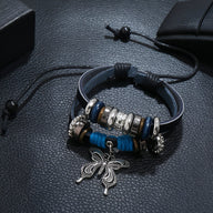 Bracelet double cuir bleu avec charms papillon argenté et perles décoratives noires et argentées.