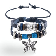 Bracelet double en cuir bleu avec perles argentées et charm papillon détaillé suspendu.