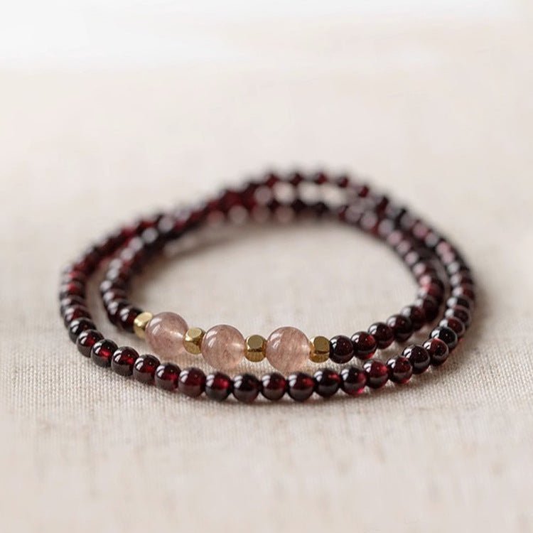 Bracelet double en perles de grenat rouge profond et quartz rose translucide avec petites perles dorées.