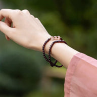 Bracelet double en grenat rouge et quartz rose sur poignet, style élégant et apaisant.