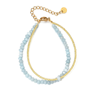 Bracelet double rang avec perles facettées bleu ciel et chaîne fine dorée ajustable.
