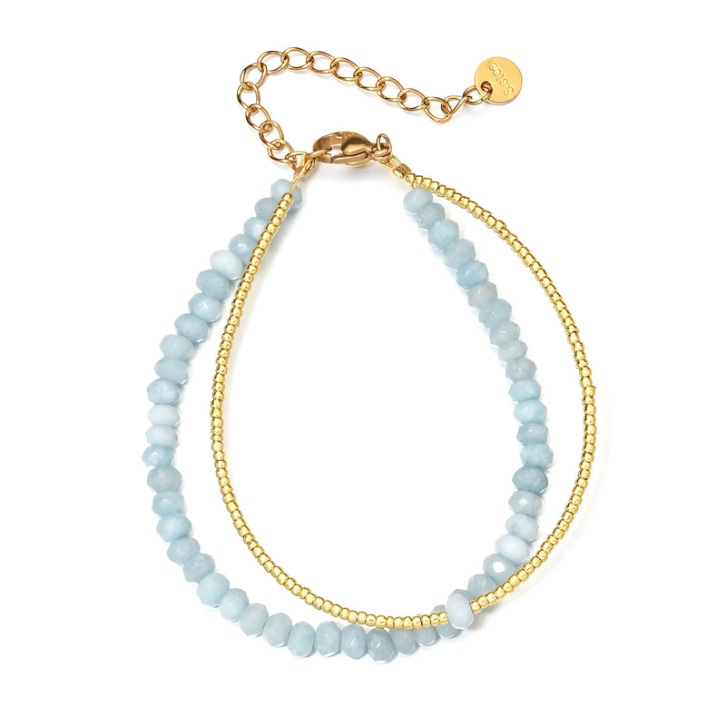 Bracelet double rang avec perles facettées bleu ciel et chaîne fine dorée ajustable.