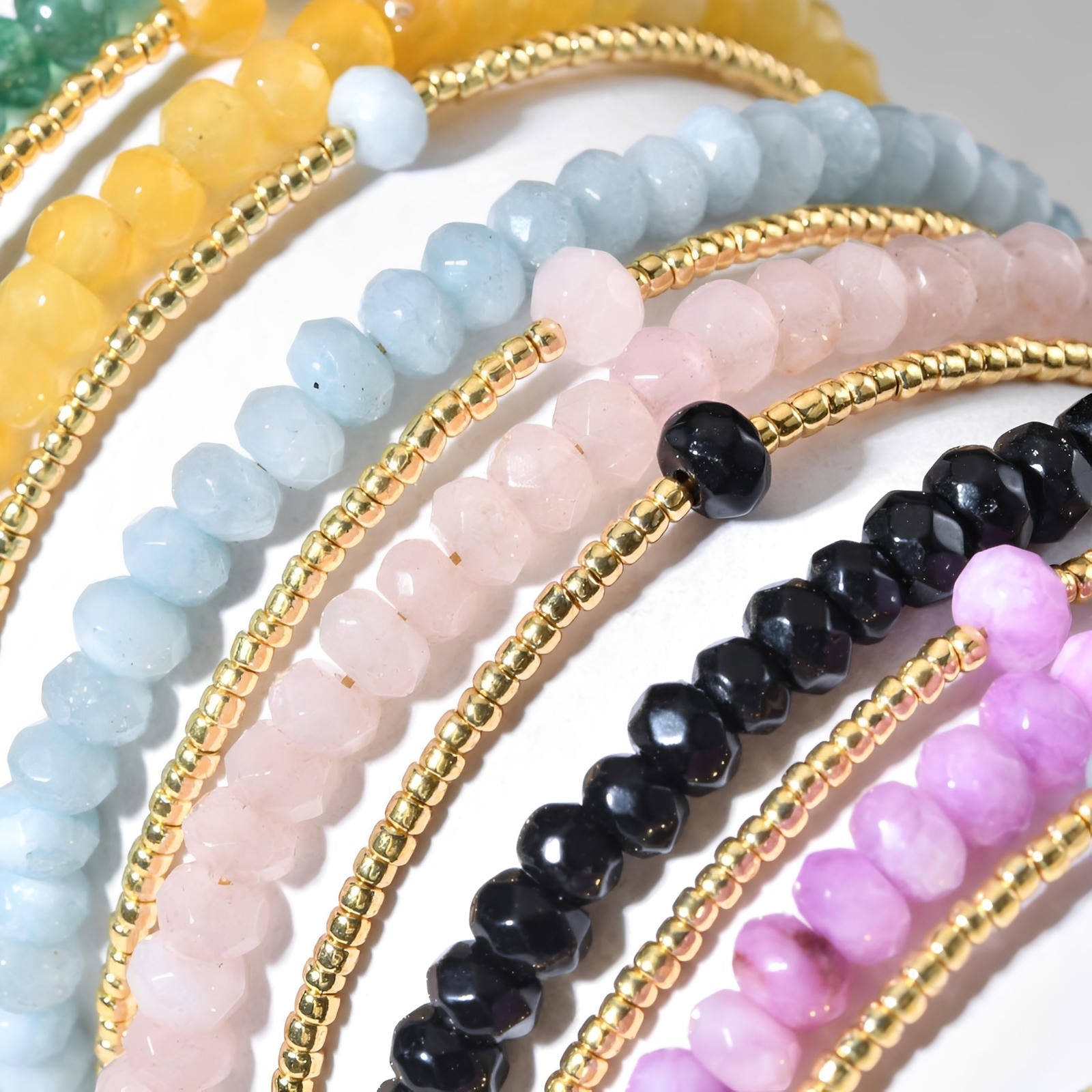 Bracelet double rang avec perles facettées turquoise, rose, noire, violette, jaune et billes dorées fines.