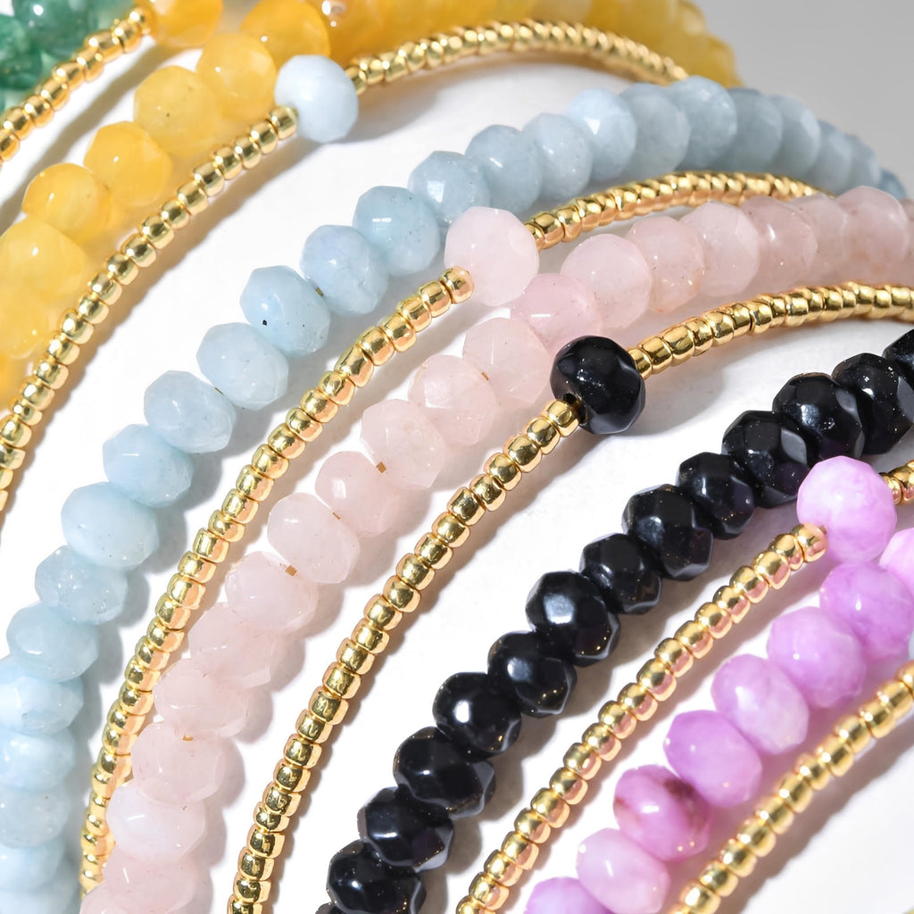 Bracelet double rang avec perles facettées turquoise, rose, noire, violette, jaune et billes dorées fines.