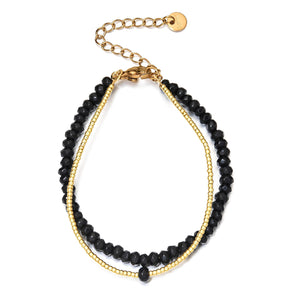 Bracelet double rang avec perles naturelles facettées noires et fines billes dorées, fermoir chaîne ajustable.