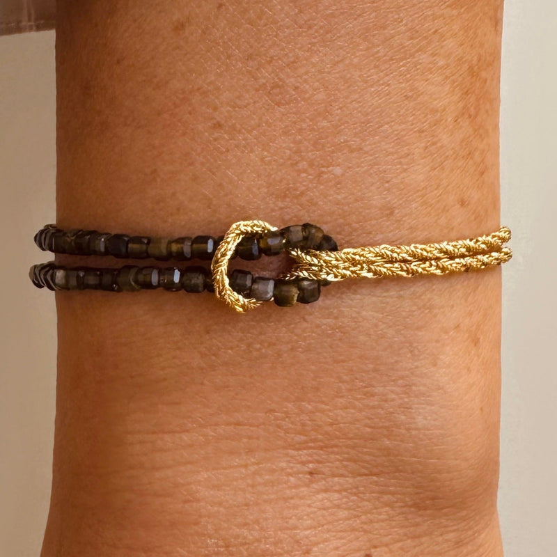 Bracelet double rang avec perles brunes en bois et corde dorée torsadée, fermoir mousqueton et nœud doré raffiné.