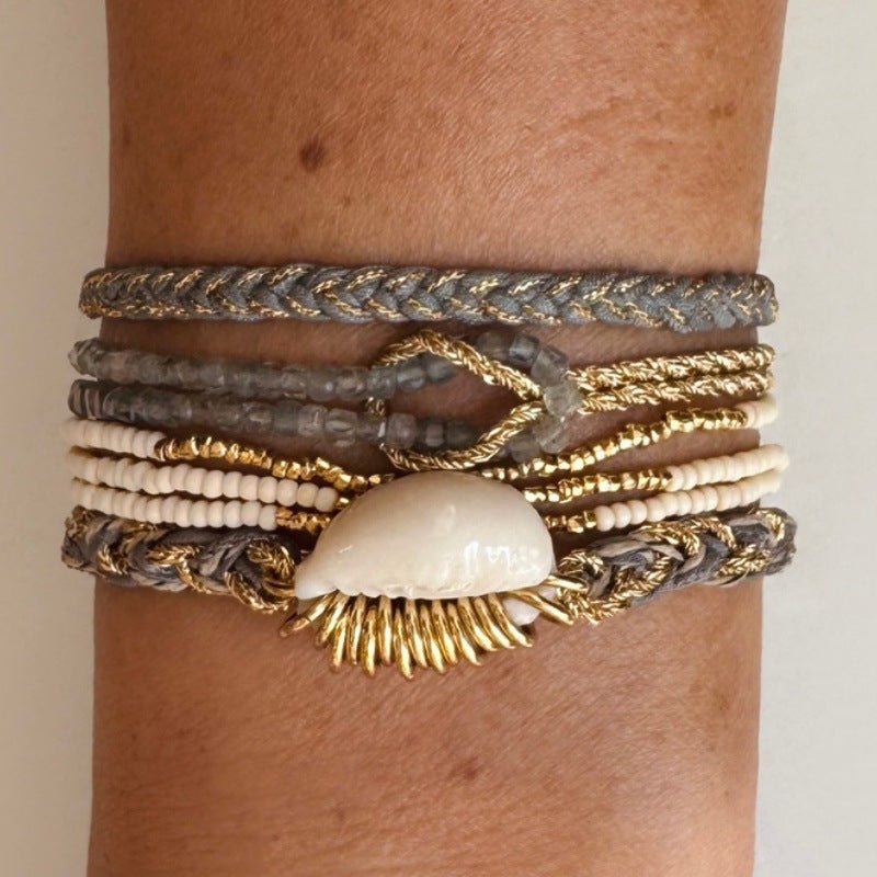 Bracelet double rang avec perles blanches nacrées et corde dorée torsadée, fermoir mousqueton, orné d’un coquillage blanc et