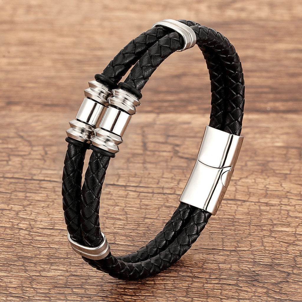 Bracelet double-rangs en microfibre noire tressée avec détails métalliques argentés et fermoir magnétique.