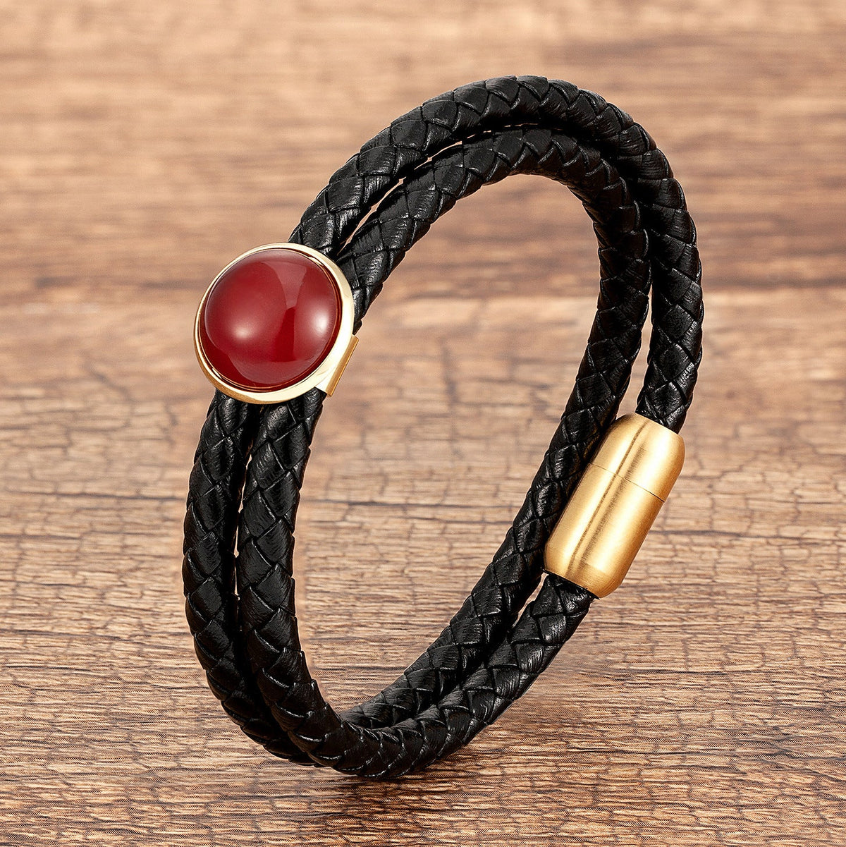 Bracelet double-rangs en microfibre noire tressée avec pierre rouge brillante et fermoir doré.