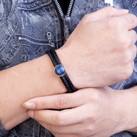 Bracelet double-rangs en microfibre noir orné d’une pierre bleue lapis lazuli ronde sur poignet masculin.