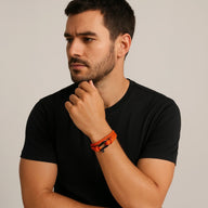 Bracelet double tour orange en nylon avec fermoir à manille en acier inoxydable porté au poignet.