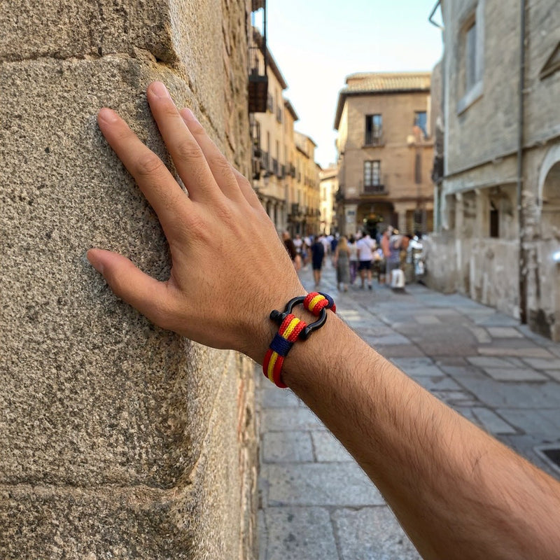 Bracelet en nylon tricolore rouge, jaune et noir avec boucle manille métallique noire, style masculin.