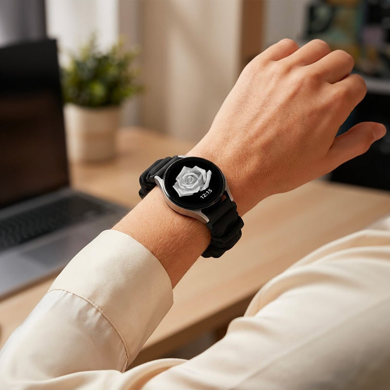 Bracelet élastique noir en tissu style chouchou pour montre connectée, ajusté au poignet.