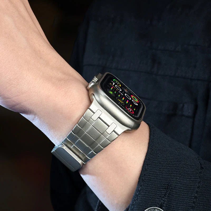 Bracelet magnétique en acier gris pour Apple Watch, maillons larges et finition mate.