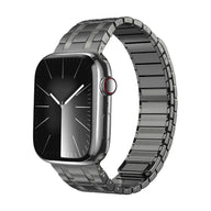 Bracelet en acier noir mat avec maillons larges et fermeture magnétique pour Apple Watch.