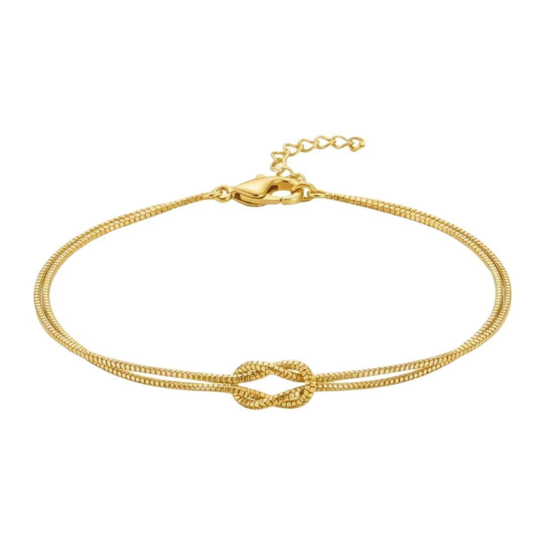 Bracelet fin en acier inoxydable doré avec nœud central texturé et fermoir chaîne réglable.
