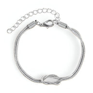 Bracelet femme en acier inoxydable argenté avec nœud central et chaîne réglable.
