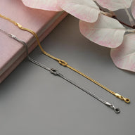 Bracelets fins en acier inoxydable or et argent avec nœud central élégant pour femme.
