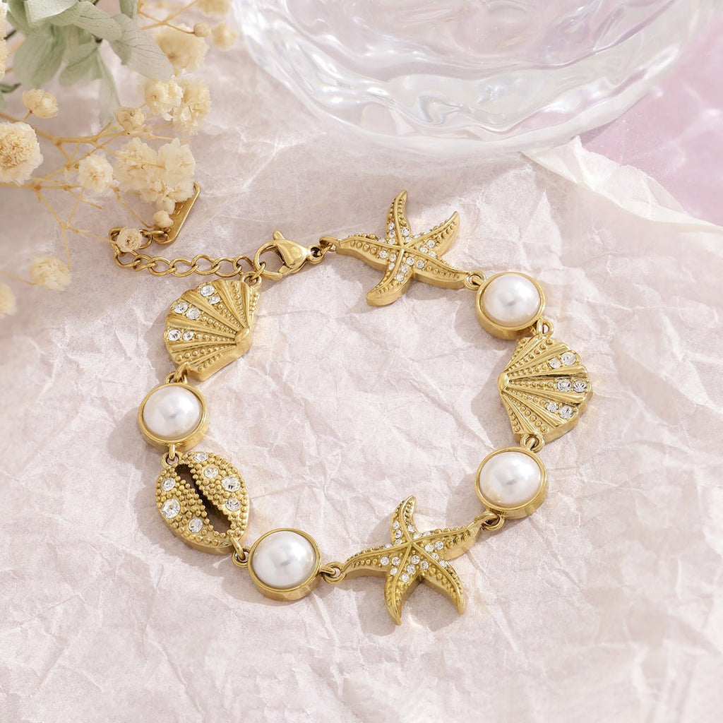 Pulsera de acero inoxidable dorado, perlas de agua dulce y dijes marinos, ajustable, modelo Ridèle