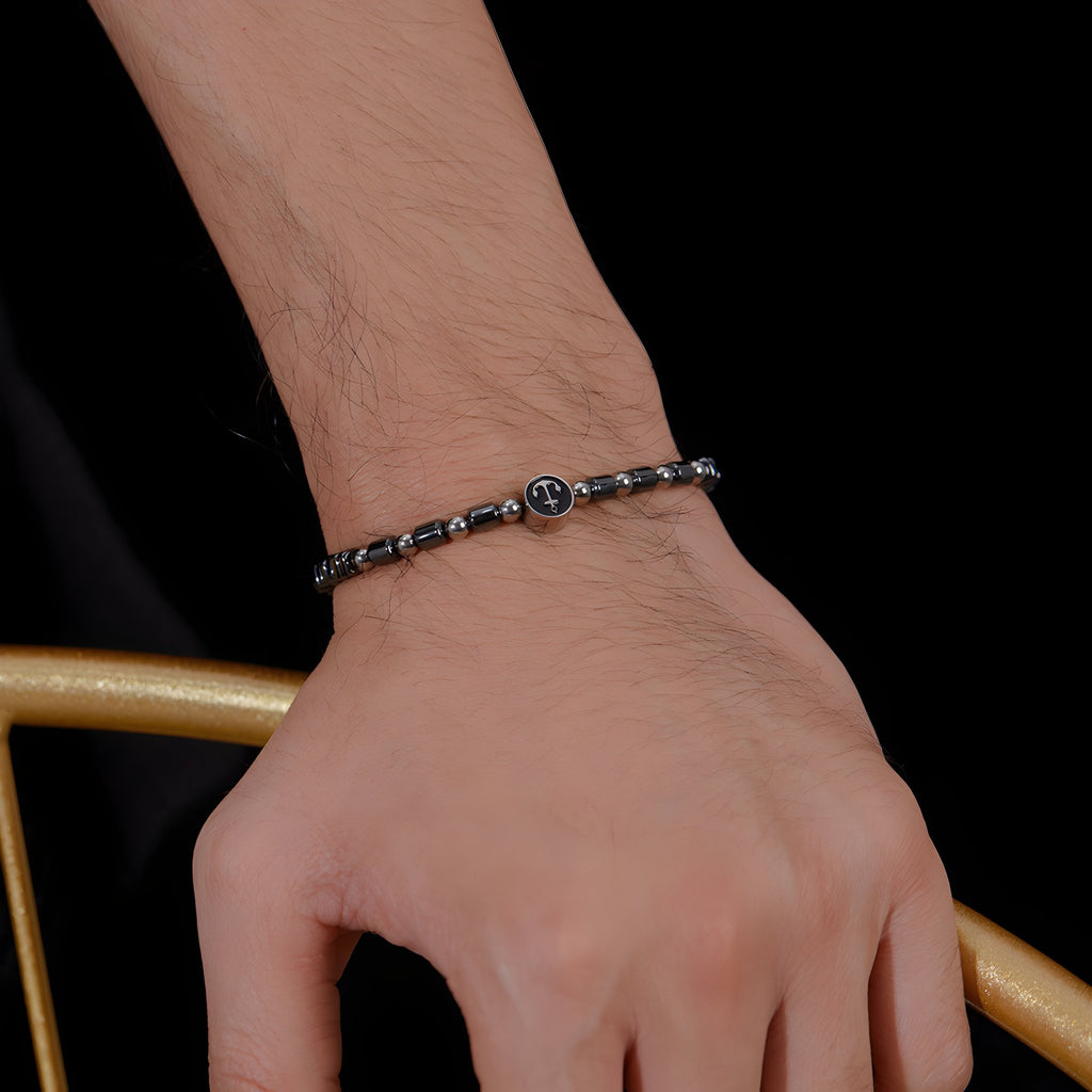 Bracelet homme en acier inoxydable avec perles d’hématite noire et charm ancre argenté.