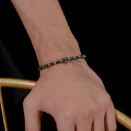 Bracelet homme en acier inoxydable avec perles d’hématite noire et charm ancre argenté.