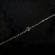 Bracelet homme en acier inoxydable argenté avec perles hématites noires et charm ancre au centre.