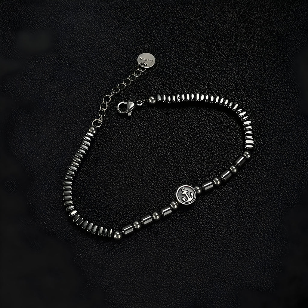 Bracelet homme en acier inoxydable et hématites noires avec charm ancre argenté, finition brillante.