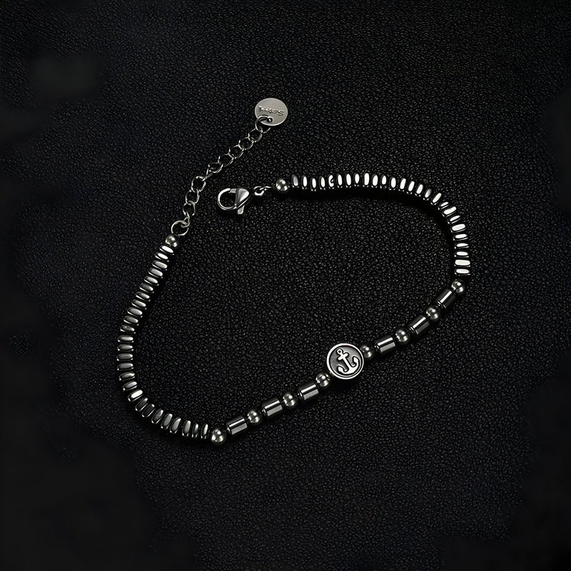Bracelet homme en acier inoxydable et hématites noires avec charm ancre argenté, finition brillante.