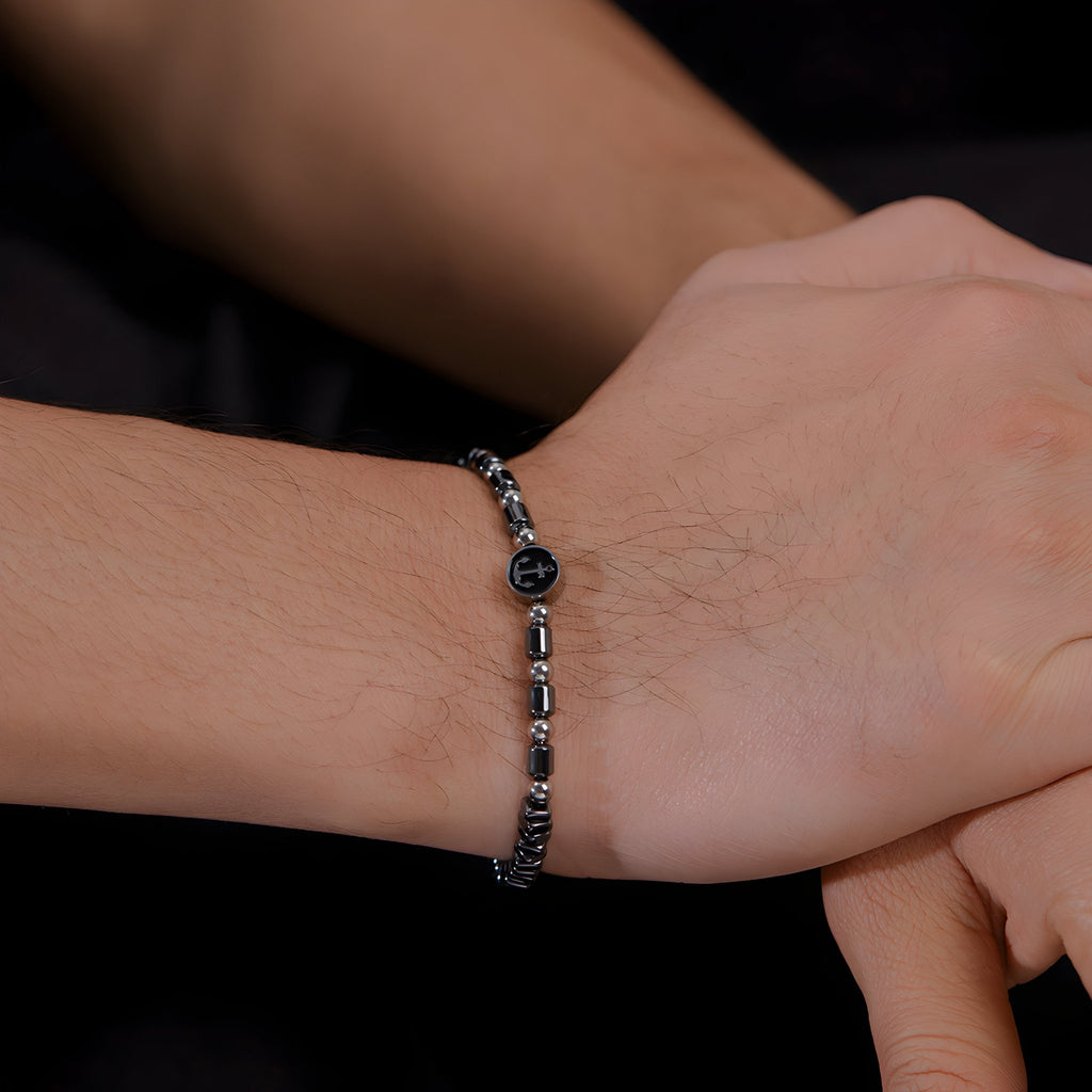 Bracelet homme en acier inoxydable avec perles d'hématite noire et charm ancre argenté.