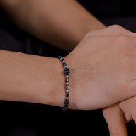 Bracelet homme en acier inoxydable avec perles d'hématite noire et charm ancre argenté.