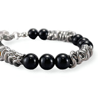 Bracelet homme en acier inoxydable argenté avec perles d'agate noire lisses et éléments en spirale.
