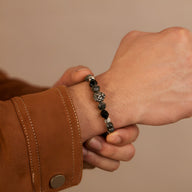 Bracelet homme en acier inoxydable argenté avec pierres noires et détail tête d’animal sculptée.