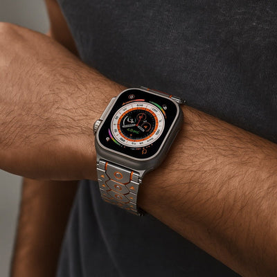Bracelet acier inoxydable argent avec détails orange, ajustable pour Apple Watch, style Halo, porté au poignet.