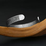 Bracelet homme en acier inoxydable argenté avec motifs celtiques gravés, design ouvert et finitions mates.