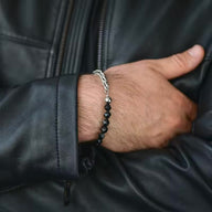 Bracelet homme acier inoxydable avec perles noires mates et chaîne argentée élégante.